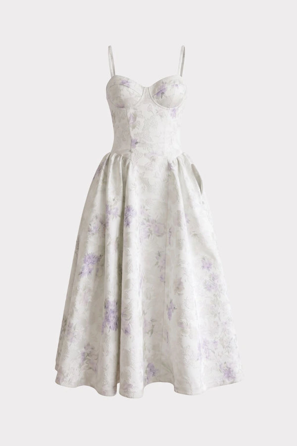 White sleeveless dress with thin straps, sweetheart neckline, fitted bodice, and full skirt with purple floral pattern.